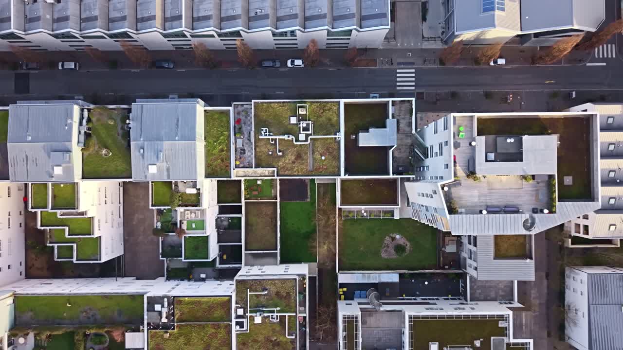 Arsitektur perumahan modern di Nantes, Prancis, yang menangkap garis bersih blok perumahan kontemporer, campuran atap hijau datar (atap ramah lingkungan) dan struktur miring metalik, tampilan udara dari atas