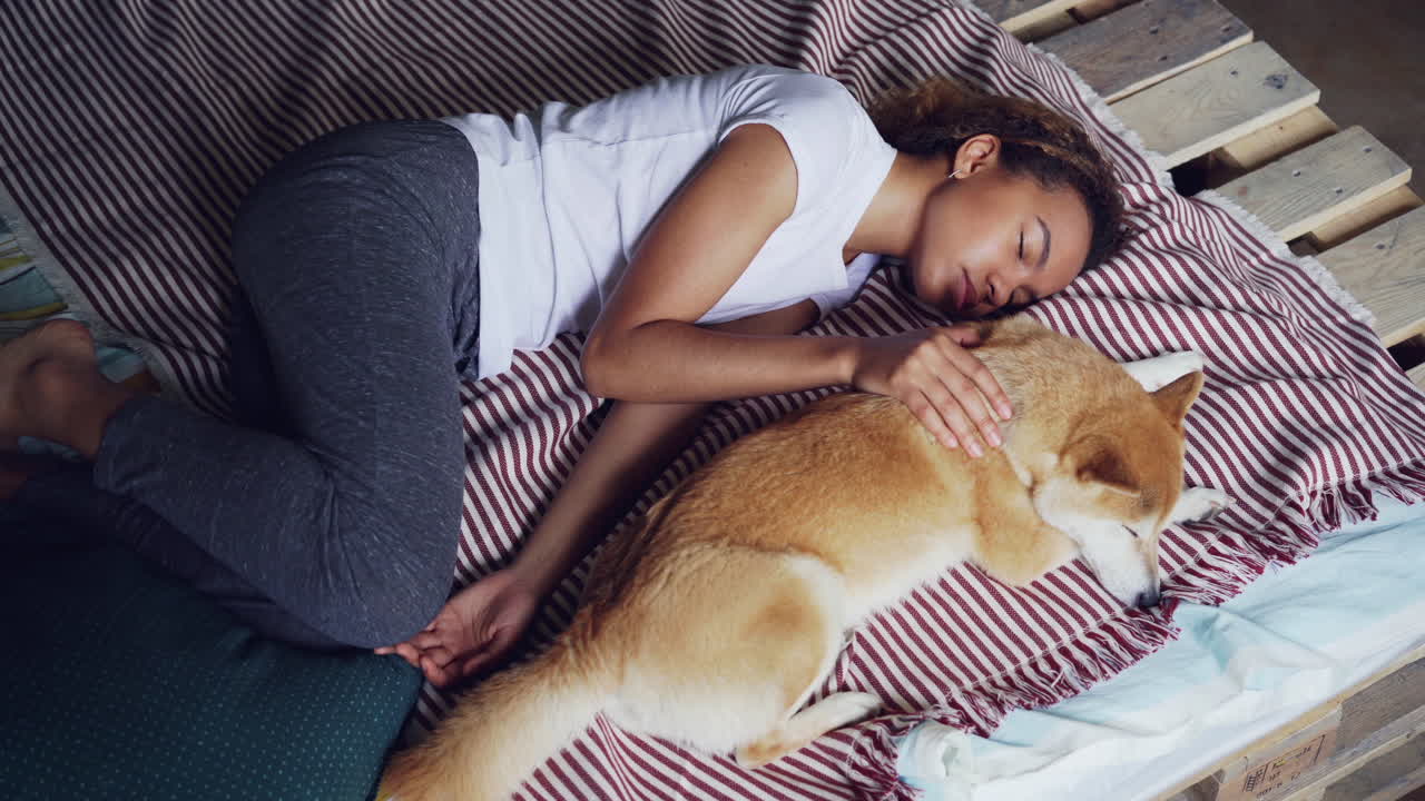 Woman and her Dog Sleeping on a Bed