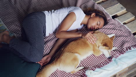woman and her dog sleeping on a bed