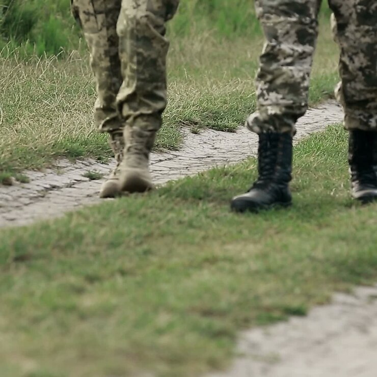 Soldati che camminano in uniformi mimetiche
