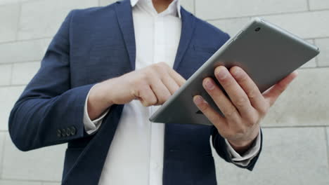 businessman using touchpad on street.manager browsing internet on digital tablet