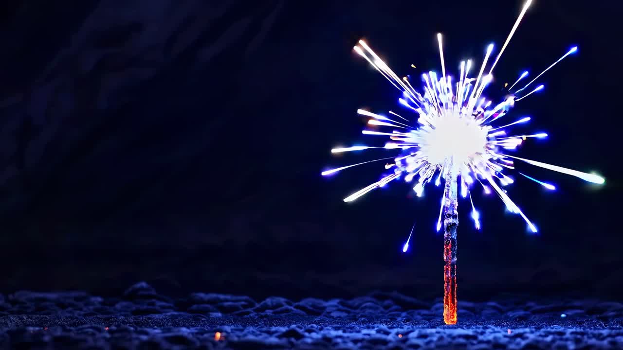 Primo piano, foto dal basso verso l'alto di una scintilla al buio, che emette vivaci scintille blu e arancioni