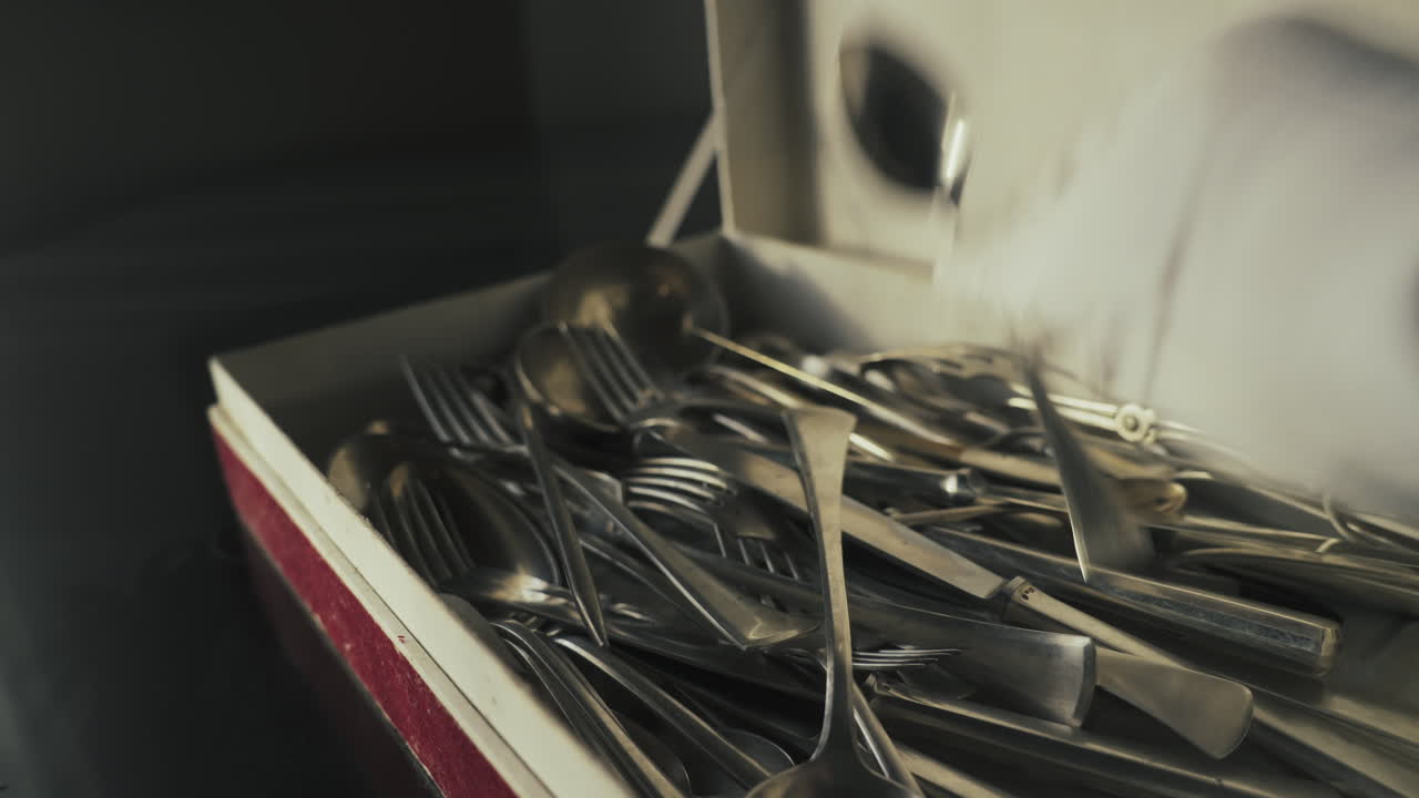 Gloved server lifts polished cutlery from presentation box. Suitable for fine dining service, formal event preparation, and premium hospitality branding