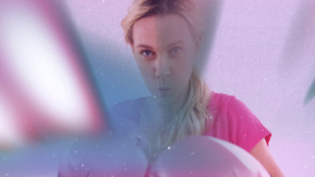 Wearing pink shirt, person creating animation with colorful, blurred motion effect