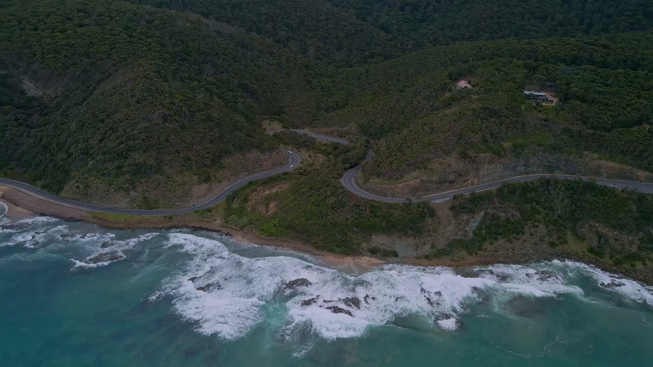 la gran carretera oceánica de australia en órbita disparada por un dron que muestra una carretera curva con olas costeras en victoria