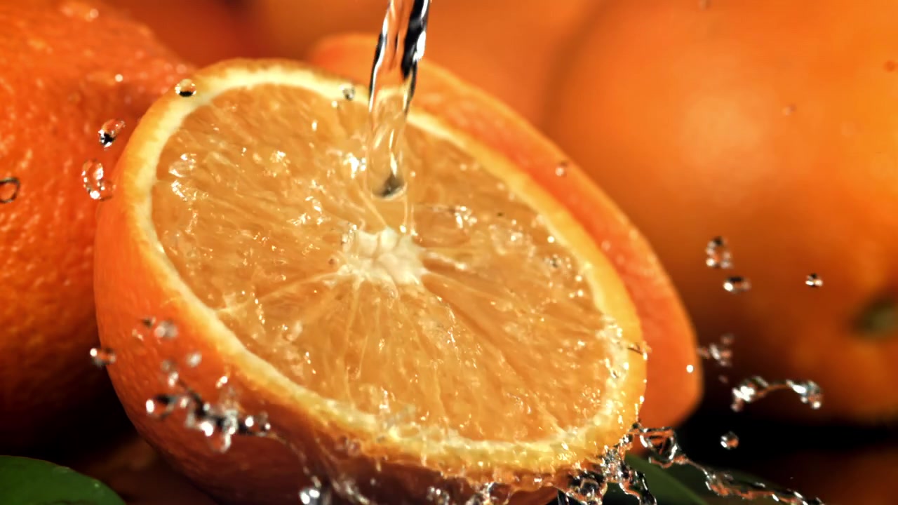 Acqua che si versa su una fetta d'arancia fresca al rallentatore