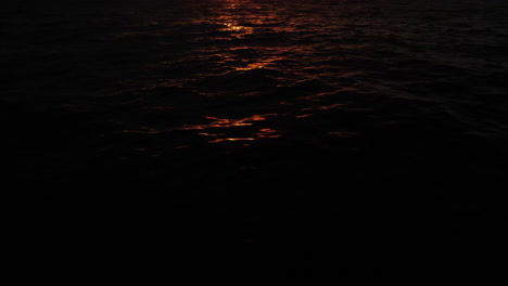 golden sun rays shining on the ocean swell as the sea ripples from a gentle current during sunset