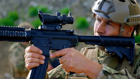 vista frontal de un soldado militar caucásico adulto entrenando con rifle en los campos durante el entrenamiento 4k