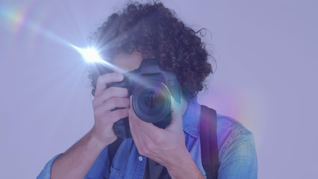 punto de luz contra afroamericano fotógrafo de sexo masculino haciendo clic en imágenes con cámara digital