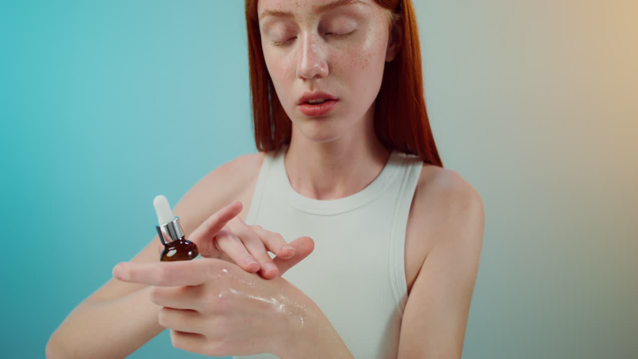 얼굴 세럼 을 바르는 젊은 여자