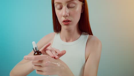 mujer joven aplicando suero facial