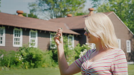 a woman holds the keys to the front door to a small wooden house tourism and travel