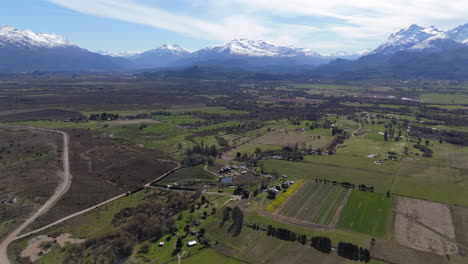 amplia vista aérea sobre campos de tulipanes, paisaje de la patagonia con montañas cubiertas de nieve a su alrededor, toma panorámica, copia del espacio
