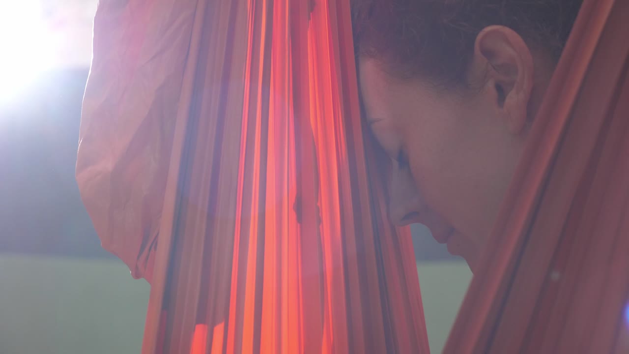 mujer practicando yoga aéreo