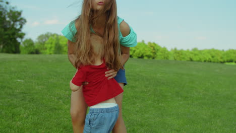 sister helping brother to get up from ground. girl holding toddler on hands