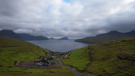 Kvivik-village-in-Streymoy-looking-out-to-Atlantic-Ocean-and-Koltur-Island,-Faroe-Islands