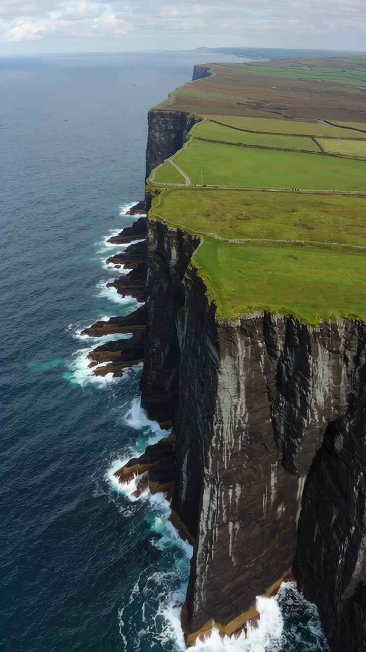 Dramatic Coastal Cliffs with Green Fields and Crashing Waves
