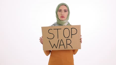 woman in hijab holding a "stop war" sign on a white background