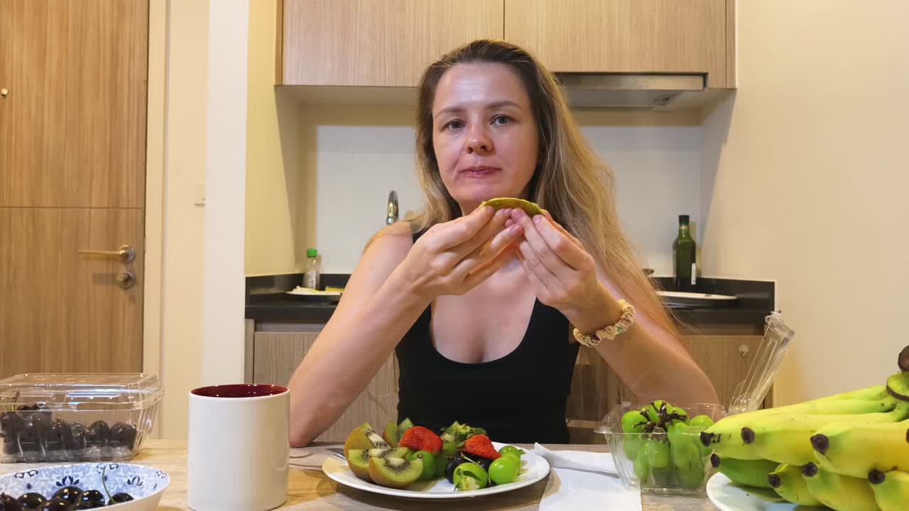 Woman eating fruit at a table