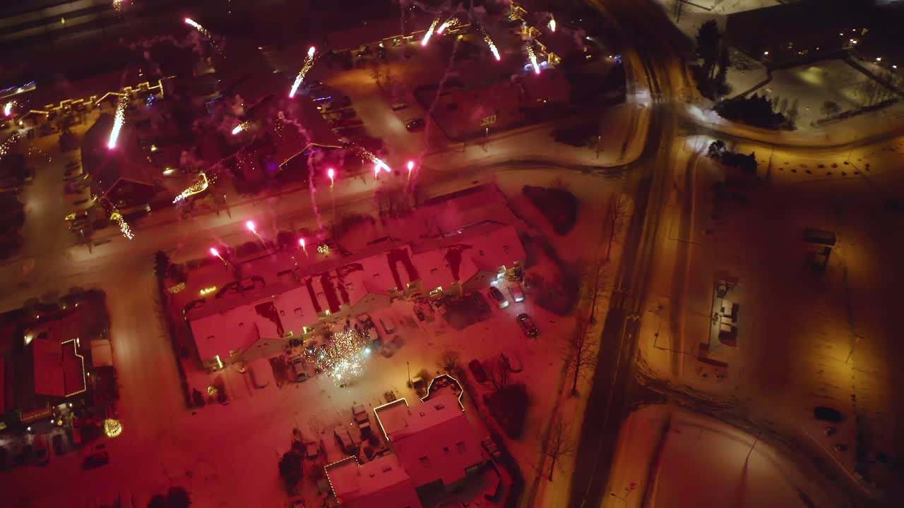 New Year's Eve Fireworks Display In Snowy Neighborhood At Night In Iceland. aerial orbiting shot