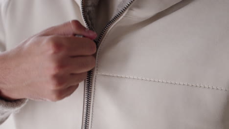 closeup of a man closing the zipoer on his jacket