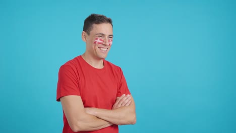 Happy man with danish flag painted on face looking away