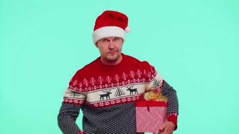 Man-in-Christmas-sweater-pointing-at-camera,-showing-stupid-gesture,-blaming-some-idiot-for-plan