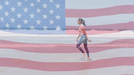 Animation-of-american-flag-moving-over-woman-dancing-on-beach