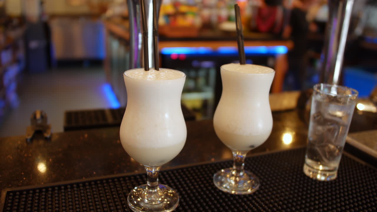 dos cócteles de piña colada en un bar