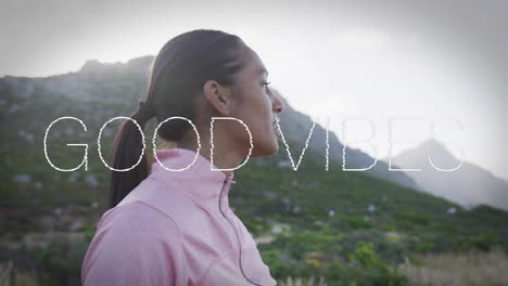 animation of the words good vibes written in white over woman exercising in mountains resting