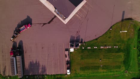 aerial view of trucks parked in a parking lot next to a farm