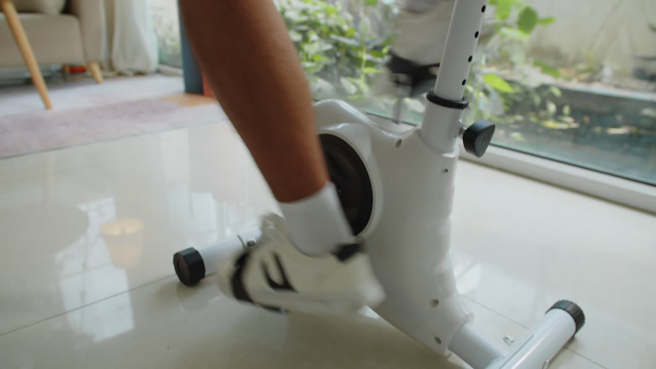 Handheld of Man Cycling on Fitness Bike