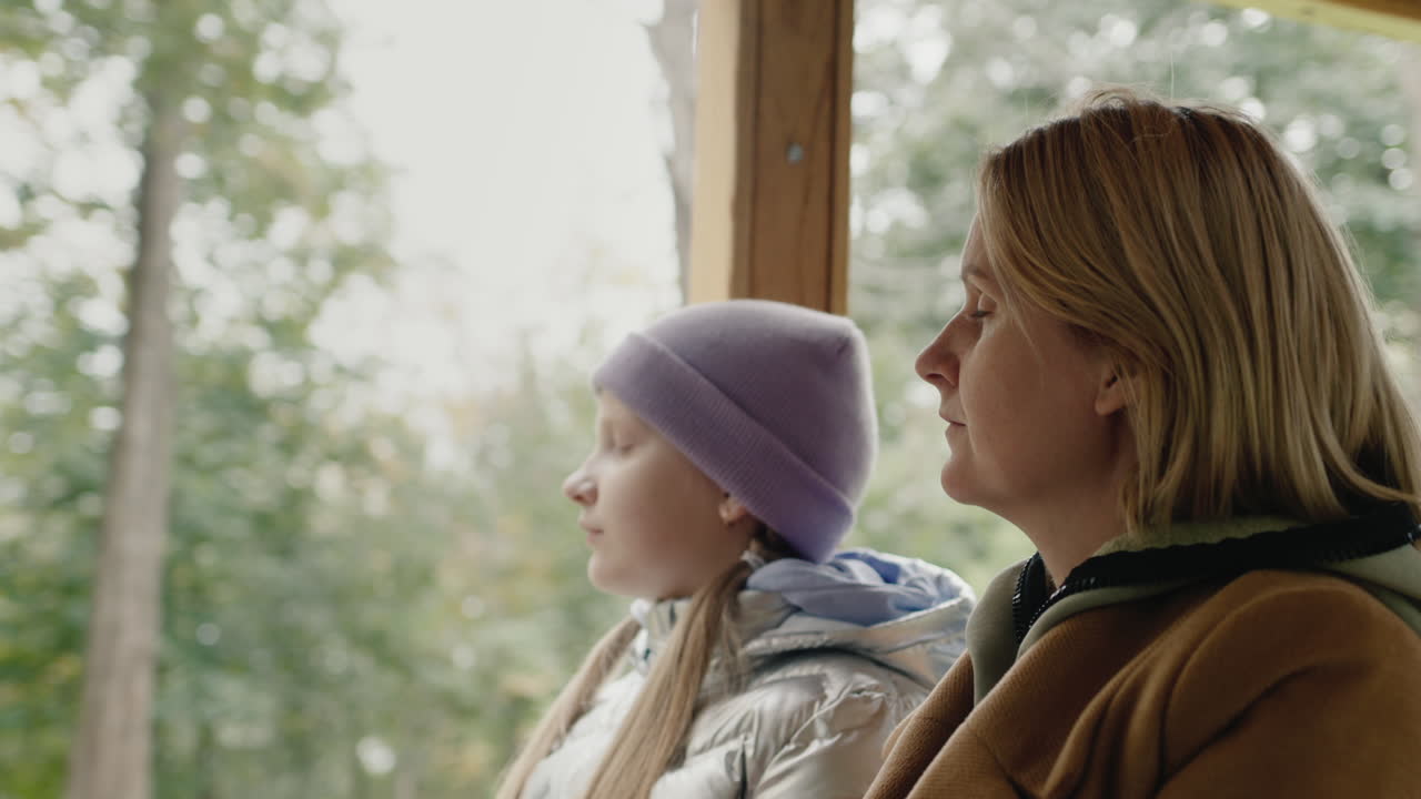 어머니 와 딸 은 창문 이 열려 있는 트램 에서 나란 히 여행 한다. 대중 교통 으로 여행