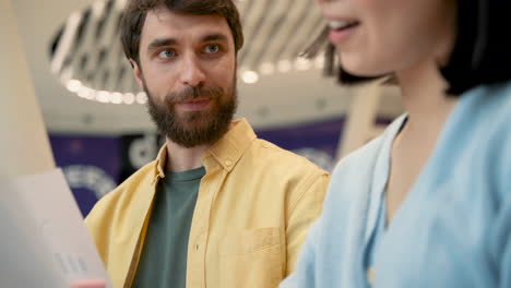 a caucasian man with glasses has a business meeting in a coffe shop with an unrecognizable asian young woman