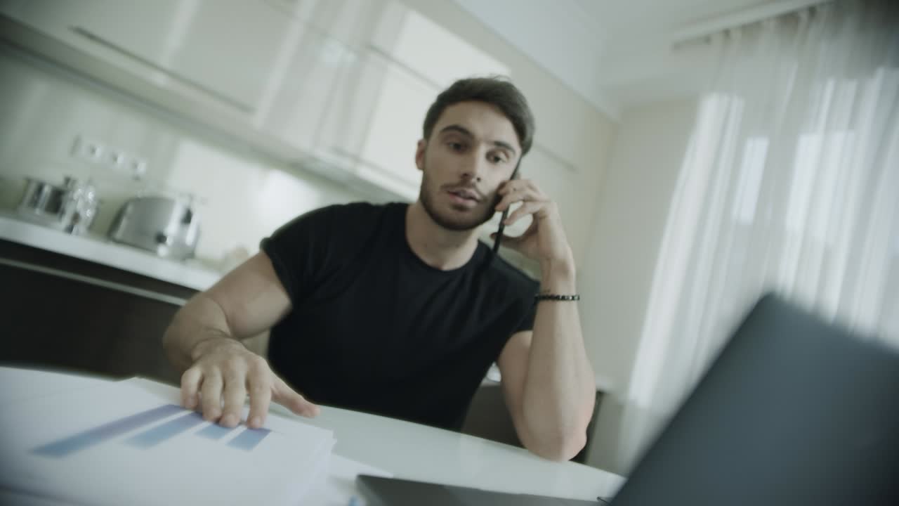 Angry business man talking mobile phone at home. Furious person throwing papers