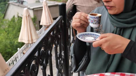 woman drinking turkish coffee on a balcony