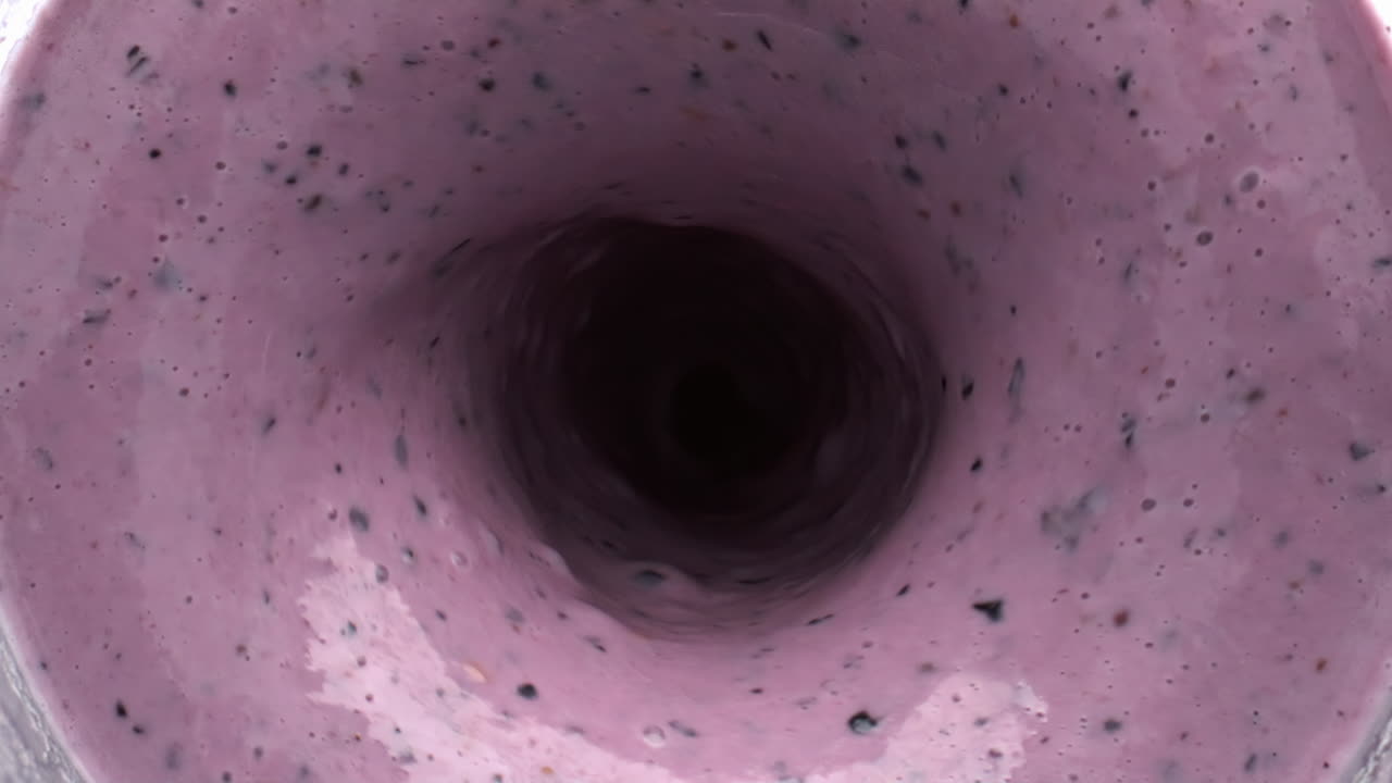 batido de bayas mezclado vista superior giratoria. vórtice líquido de batido de frutas en el cuenco