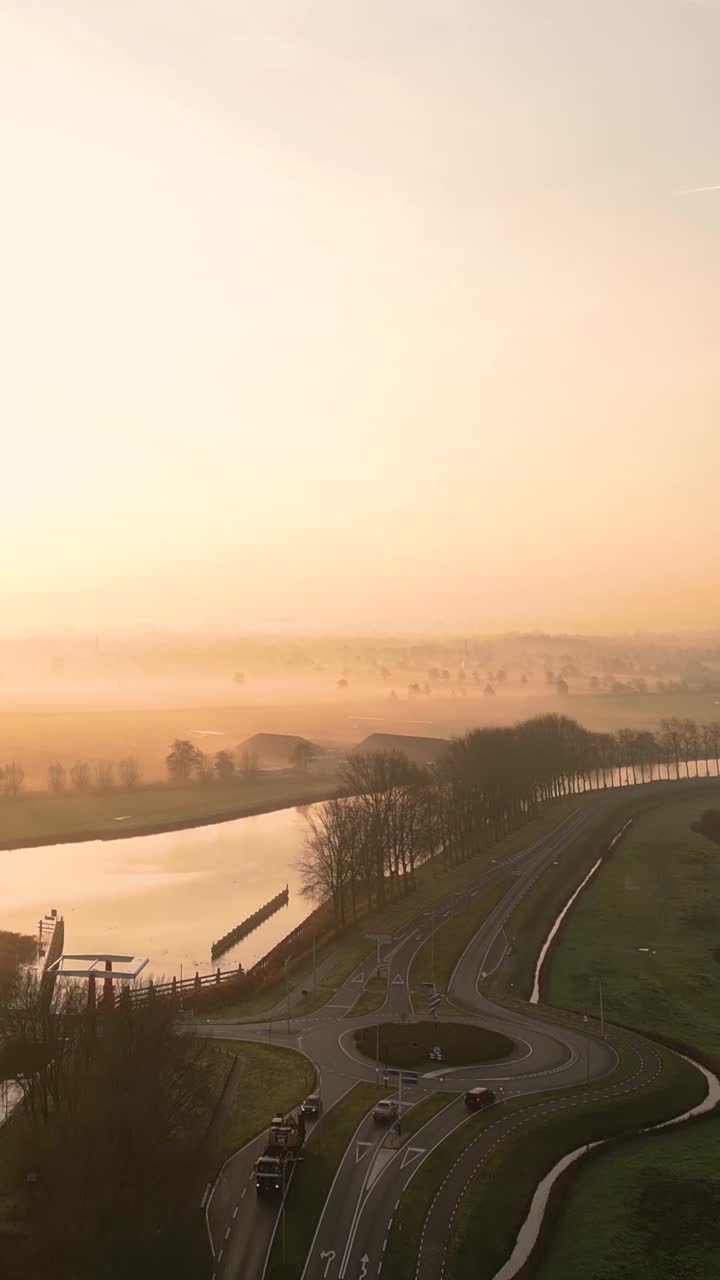 네덜란드 운하 위의 안개가 가득한 해가 뜨는 것