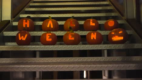 carved out pumpkins that spell out halloween with candle light burning and glowing in them