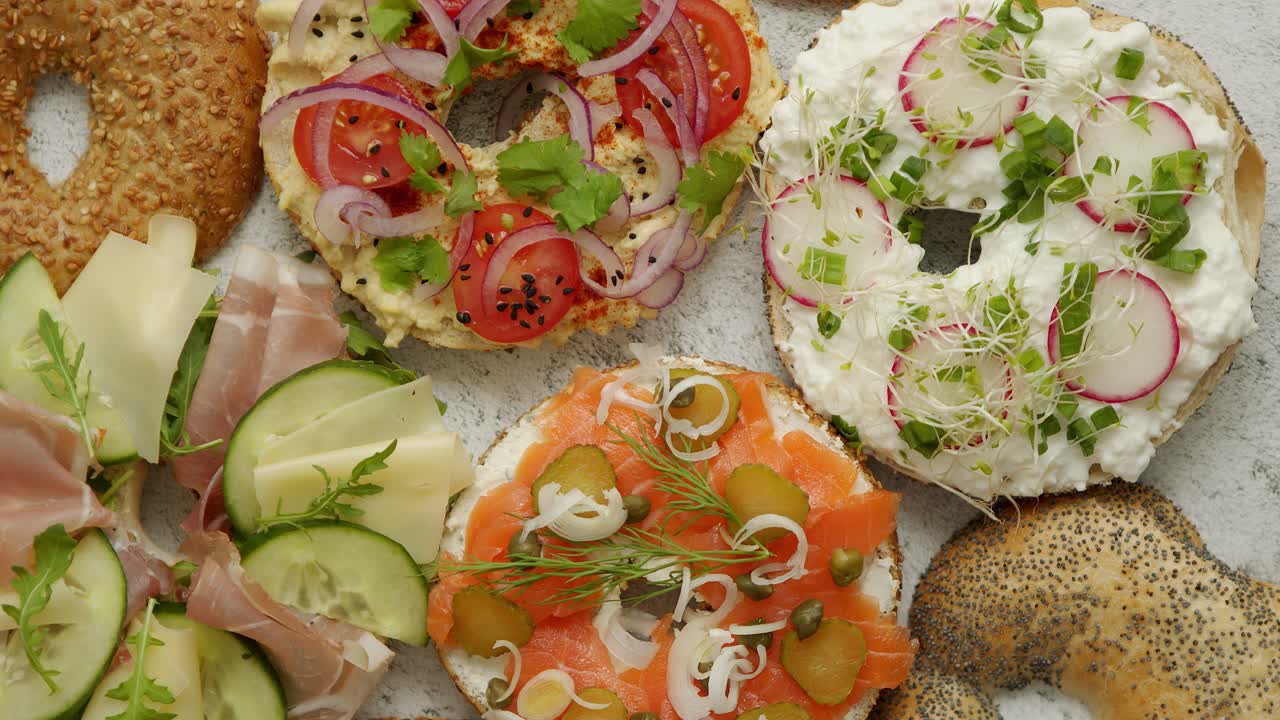 다양한 토핑과 함께 베이글 샌드위치, 연어, 코티지 치즈, 후무스, 햄, 라면 및 신선한 허브