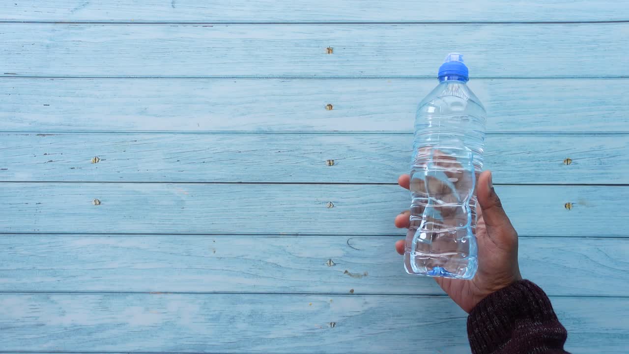 persona que sostiene una botella de agua
