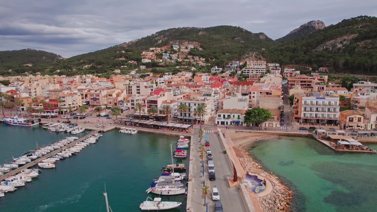 Epic wide aerial flying over yachts in the marina of the famous Port d'Andratx harbor on the island of Mallorca, Spain, a popular Mediterranean vacation destination for sailing, fishing and dining