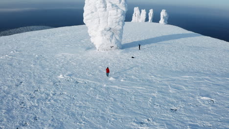 winter mountain landscape with ice sculptures and hikers