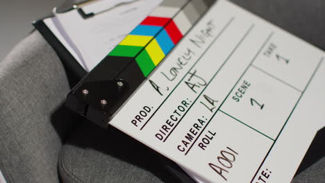 close up of film clapperboard or slate with production details and script shooting movie or video in studio 1