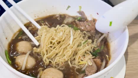 delicious beef noodles being prepared and enjoyed