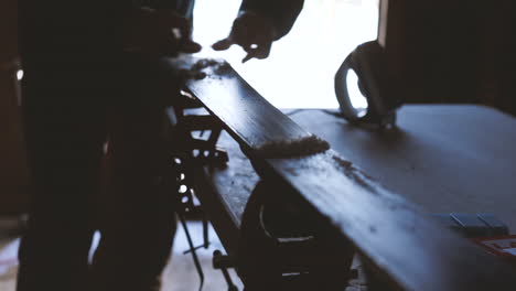 person scrapes wax off of skis while waxing skis
