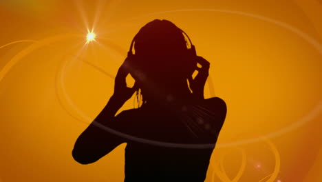 animation of silhouette of a woman dancing listening to music with headphones on orange background