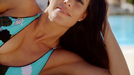 woman lying down at the poolside  leaning on arm