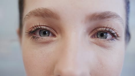 primer plano de los ojos azules de una enfermera caucásica sonriente, en cámara lenta