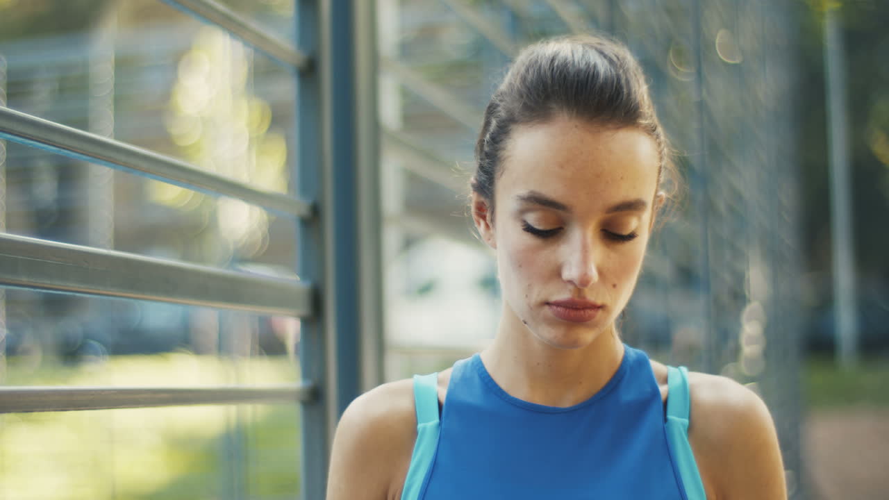 mujer deportiva bebiendo agua fría en la cancha al aire libre en un día de verano